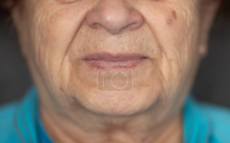 Foto de Cierra los labios de una mujer madura. Boca de anciana. Mujer mayor con la piel arrugada. - Imagen libre de derechos