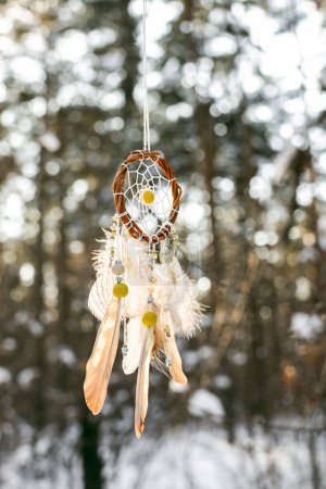 Photo for Handmade colorfull dream catcher in the snowy forest. Tribal elements, owl feathers - Royalty Free Image