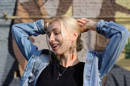 Photo for Close-up emotional portrait of gorgeous blonde woman in boho chic feather earrings, bohemian jewelry - Royalty Free Image