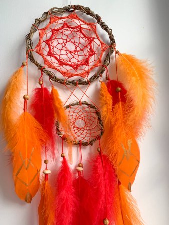 Foto de Close-up rojo naranja detalles atrapasueños tribal bohemio artesanía pared colgando decoración del hogar - Imagen libre de derechos