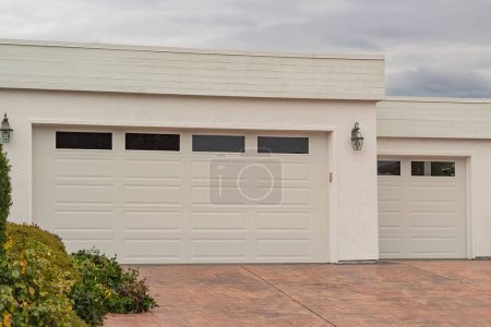 Photo for Double garage with short driveway in day Closed garage door with windows. Nobody, street photo - Royalty Free Image