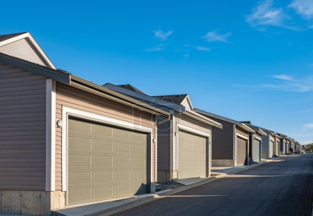 Photo for Row of garage doors at parking area for townhouses. Private garages for storage or cars in rows in Canada. Street photo, nobody, selective focus - Royalty Free Image