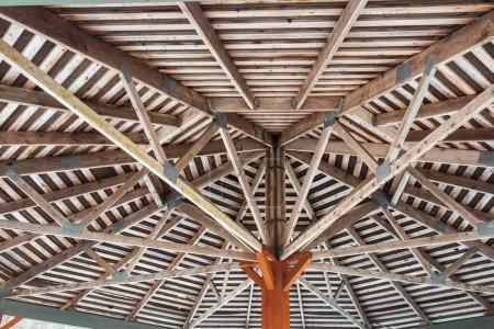 Photo for Part of the wooden roof structure on the gazebo. The inside roof of a wooden garden gazebo, looking up and out from within. Nobody, selective focus - Royalty Free Image
