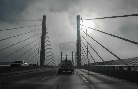 Foto de Puente colgante. Golden Ears Bridge con tráfico en la mañana brumosa, desenfoque de movimiento. Entre Langley y Maple Ridge, BC, Canadá-Diciembre 12,2022 - Imagen libre de derechos