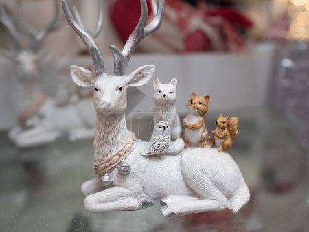 Foto de Figura decorativa de Navidad de renos sobre fondo borroso. Decoración de juguetes de Navidad hechos a mano. Escena navideña festiva, bosque nevado en miniatura con lindos ciervos - Imagen libre de derechos