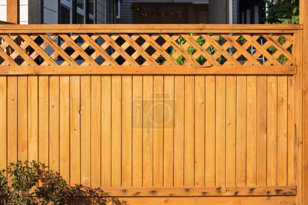 Photo for Nice wooden fence around house. Wooden fence with green lawn. Street photo, nobody, selective focus - Royalty Free Image