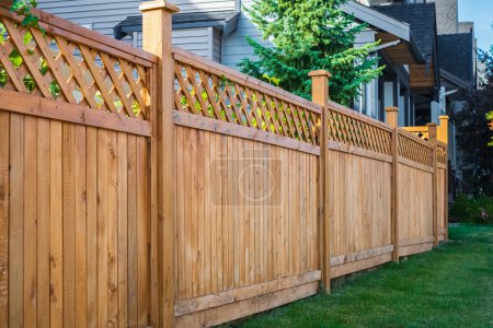 Photo for Nice wooden fence around house. Wooden fence with green lawn. Street photo, nobody, selective focus - Royalty Free Image