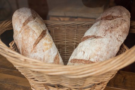 Téléchargez les photos : Homemade bread, small bakery, natural farm products, domestic production. Healthy and tasty organic food. Basket with various bread freshly baked. Traditional fresh baked bread in a basket - en image libre de droit