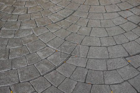 Foto de Stamped concrete pavement cobblestones pattern, decorative appearance textures of paving cobblestones tile on cement flooring in a park. Printed grey concrete path. Nobody - Imagen libre de derechos