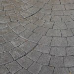 Stamped concrete pavement cobblestones pattern, decorative appearance textures of paving cobblestones tile on cement flooring in a park. Printed grey concrete path. Nobody