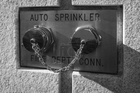 Téléchargez les photos : Auto sprinkler standpipe connector. Fire department connection covered outside of a building on a wall. Selective focus. Fire Department Connections for Sprinkler Systems and pump on the exterior wall - en image libre de droit