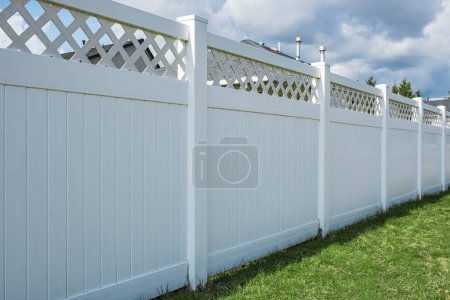 Photo for Nice new white wooden fence around house. Wooden fence with green lawn. Street photo, nobody, selective focus - Royalty Free Image