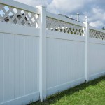 Nice new white wooden fence around house. Wooden fence with green lawn. Street photo, nobody, selective focus