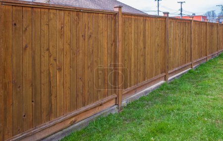 Photo for Nice new wooden fence around house. Wooden white fence with green lawn. Street photo, nobody, selective focus - Royalty Free Image