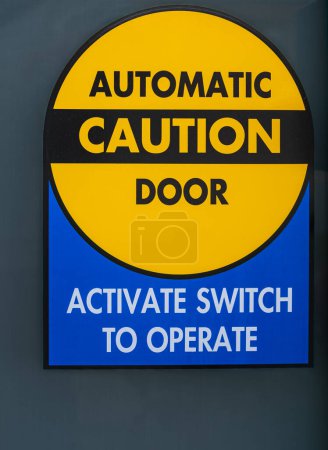 Automatisches Türschild zur Vorsicht. Automatische Glastüren mit gelbem Schild Vorsicht. Straßenfoto, niemand