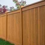 Nice wooden fence around house. Wooden fence with green lawn. Street photo, nobody, selective focus