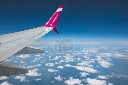 Photo for Photo of Airplane wing against blue sky, flyinig over the clouds. A Swoop Boeing 737-800 shortly after taking off from the Toronto International Airport. Low cost airline. Canada Toronto-June 17, 2023 - Royalty Free Image