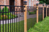 Wrought Iron Fence. Metal black fence around house with green lawn. Street photo, nobody Poster #663700566