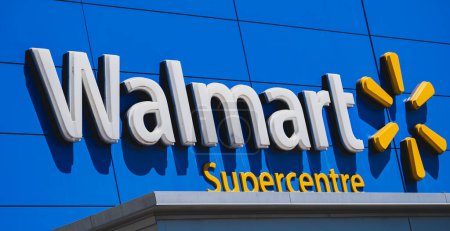 Foto de Marca de fachada exterior de supertienda Walmart y señalización de logotipo sobre fondo azul. Walmart es una multinacional estadounidense de retail que opera una cadena de hipermercados-20 de julio de 2023-Surrey Canada - Imagen libre de derechos