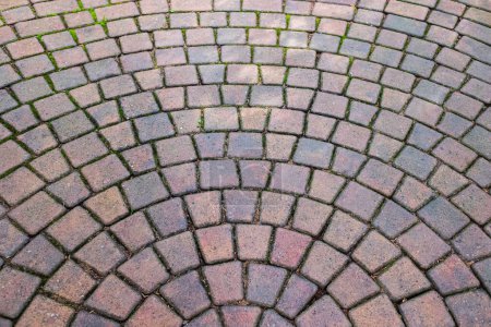 Stamped concrete pavement cobblestones pattern, decorative appearance textures of paving cobblestones tile on cement flooring in a park. Printed concrete path. Nobody