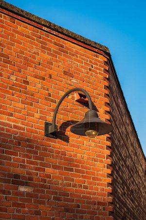 Photo for Vintage old street lantern with on a brick wall. Wall street light. Old style lantern, brick wall with shadow. Old grunge street. Grungy urban background of a brick wall - Royalty Free Image