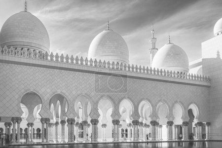 Detail of Sheikh Zayed Grand Mosque on the blue sky background. Black and white photo of Sheikh Zayed Grand Mosque, Abu Dhabi on a sunny day. Pillars and pool Grand Mosque in Abu Dhabi. Travel photo