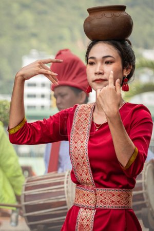 Foto de Mujeres jóvenes vestidas con ropa tradicional vietnamita Realización de bailes tradicionales vietnamitas con una olla de barro en la cabeza. Mujeres asiáticas - artistas callejeros-Nha Trang en Vietnam-Marzo 28,2024 - Imagen libre de derechos