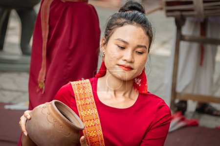 Foto de Mujeres jóvenes vestidas con ropa tradicional vietnamita Realización de bailes tradicionales vietnamitas con una olla de barro en la cabeza. Mujeres asiáticas - artistas callejeros-Nha Trang en Vietnam-Marzo 28,2024 - Imagen libre de derechos