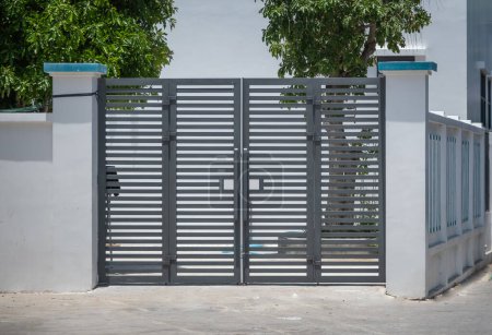 Puerta moderna de la casa del panel en color gris. La puerta de entrada de la casa. Puerta de diseño horizontal de metal para la casa. Puerta de entrada de hierro.
