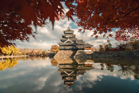 Photo for Matsumoto Castle in Autumn with Red Maple Leaf on Sunny Day, Crow Castle, Matsumoto, Nagano prefecture, Japan. Matsumoto Castle is one of Japan's premier historic castle. - Royalty Free Image