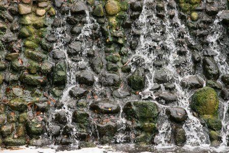Foto de Vista de una pared de piedra y el agua que fluye por la pared, una cascada - Imagen libre de derechos
