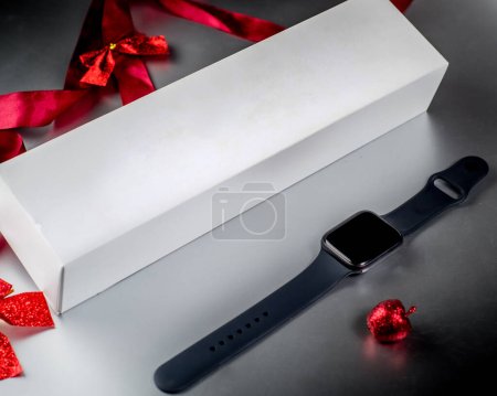 Photo for Smartwatch as a Christmas gift on the background of Christmas decorations. Smart watch gift box with copy space - Royalty Free Image