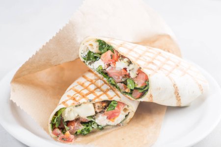 Téléchargez les photos : Rouleau de pita au saumon et légumes. Shawarma en pain pita farci aux légumes et au poisson - en image libre de droit