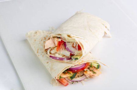 Téléchargez les photos : Rouleau de pita au poulet et légumes. Shawarma en pain pita farci aux légumes et à la viande - en image libre de droit