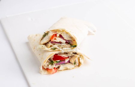 Téléchargez les photos : Rouleau de pita au poulet et légumes. Shawarma en pain pita farci aux légumes et à la viande - en image libre de droit