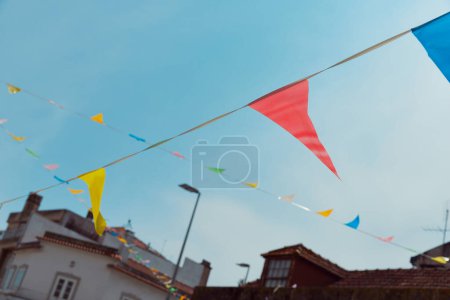 Bunting festivo y linternas decoran una calle estrecha para el festival de verano en junio San Juan, Portugal