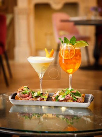 Téléchargez les photos : A servi de délicieux cocktails apéritifs et bruschettas sur la table dans le restaurant à la lumière vive - en image libre de droit