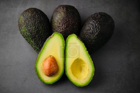 Stock photo of fresh green organic avocados isolated on black background.