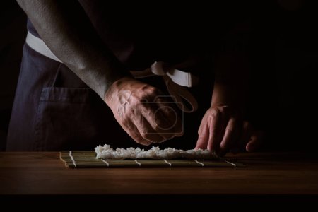 Téléchargez les photos : Homme shushi homme mains préparant différents morceaux de makis - en image libre de droit