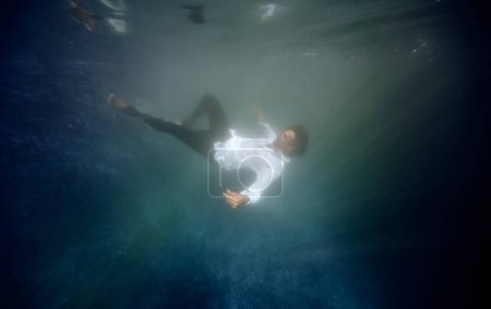 Photo for Underwater view of mature male in clothes drowning in water of swimming pool - Royalty Free Image