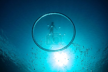 Téléchargez les photos : Plan sous-marin de grand anneau à bulles contre garçon plongeant dans l'océan bleu profond pendant les vacances - en image libre de droit