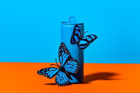 Téléchargez les photos : Papillons en plastique fragiles attachés sur bouteille boîte bleue sur fond coloré - en image libre de droit