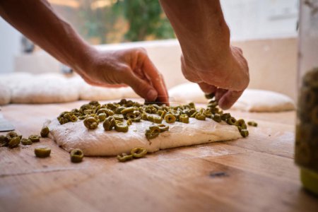 Foto de Detalle de las manos de un panadero introduciendo ingredientes en la masa de pan. .. Foto de alta calidad - Imagen libre de derechos