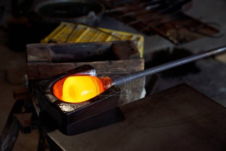 Foto de Alto ángulo de vidrio ardiente que se forma antes de ser soplado en la fábrica de fabricación de vidrio - Imagen libre de derechos