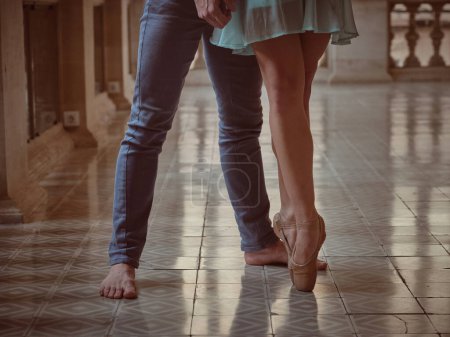 Téléchargez les photos : Femme sans visage en pointe chaussures debout avec partenaire pieds nus en jeans sur le sol carrelé dans le hall - en image libre de droit