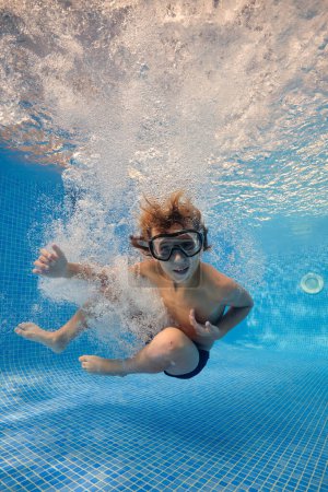 Téléchargez les photos : Corps complet de garçon pieds nus dans des lunettes de saut dans l'eau transparente claire de la piscine avec des bulles - en image libre de droit