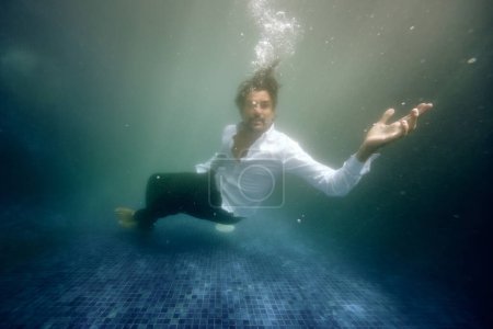 Photo for Underwater view of frustrated lonely male sinking in deep water of swimming pool - Royalty Free Image