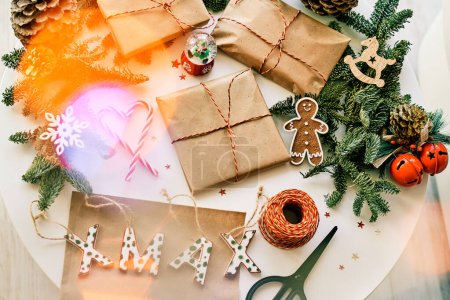 Foto de De arriba de regalos de Navidad envueltos colocados en mesa redonda con decoraciones y bastones de caramelo y galletas - Imagen libre de derechos