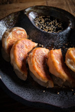 Téléchargez les photos : Des boulettes chinoises typiques. Gyoza farci de viande hachée ou de légumes et roulé en pâte mince - en image libre de droit