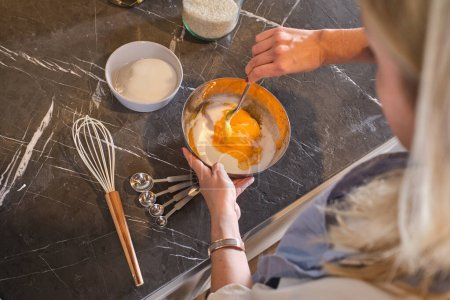 Photo for High angle of crop anonymous female mixing different ingredients for tasty dish on granite table in kitchen - Royalty Free Image